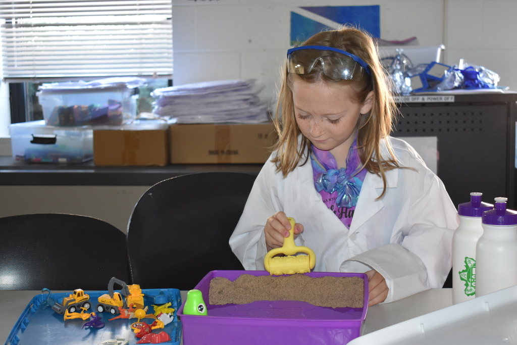 A young girl playing with a sand toy