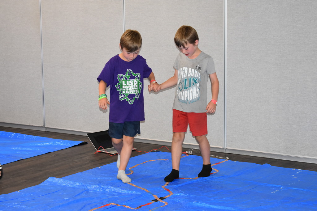 Two students showing their circuit activity to their family member