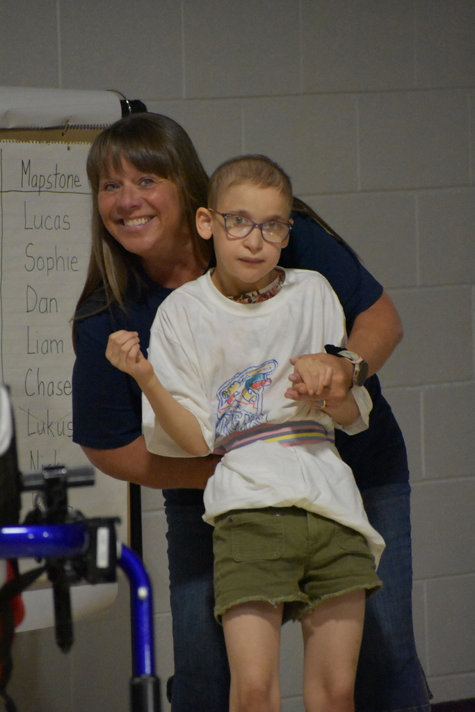 A student and teacher posing for a photo and smiling at the camera