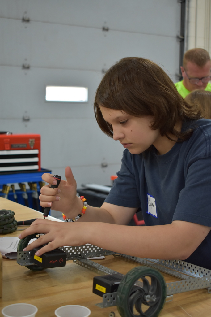 A young student working on building a robotic machine
