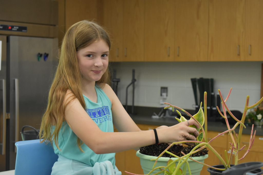 A student working with soil in a pot