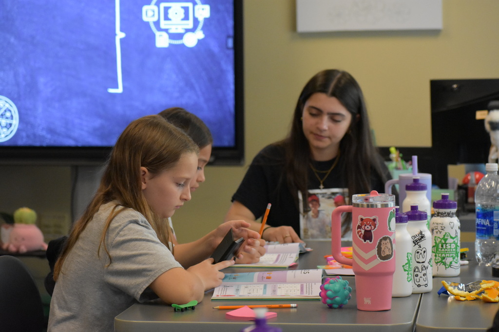 A teacher and students working at a table