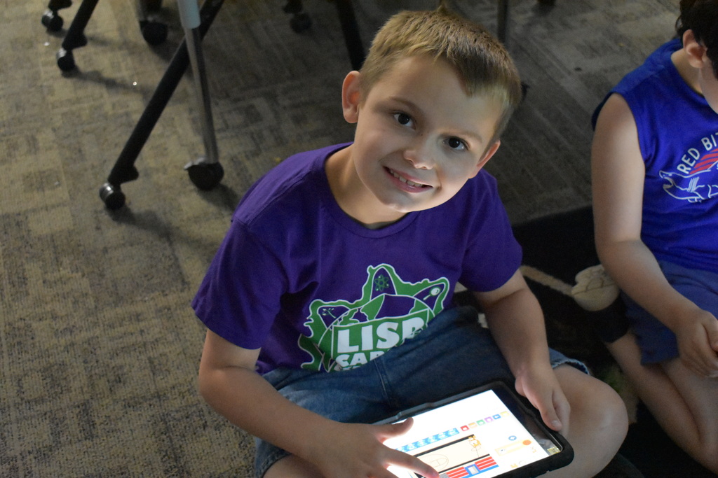 A young student playing a game on an ipad
