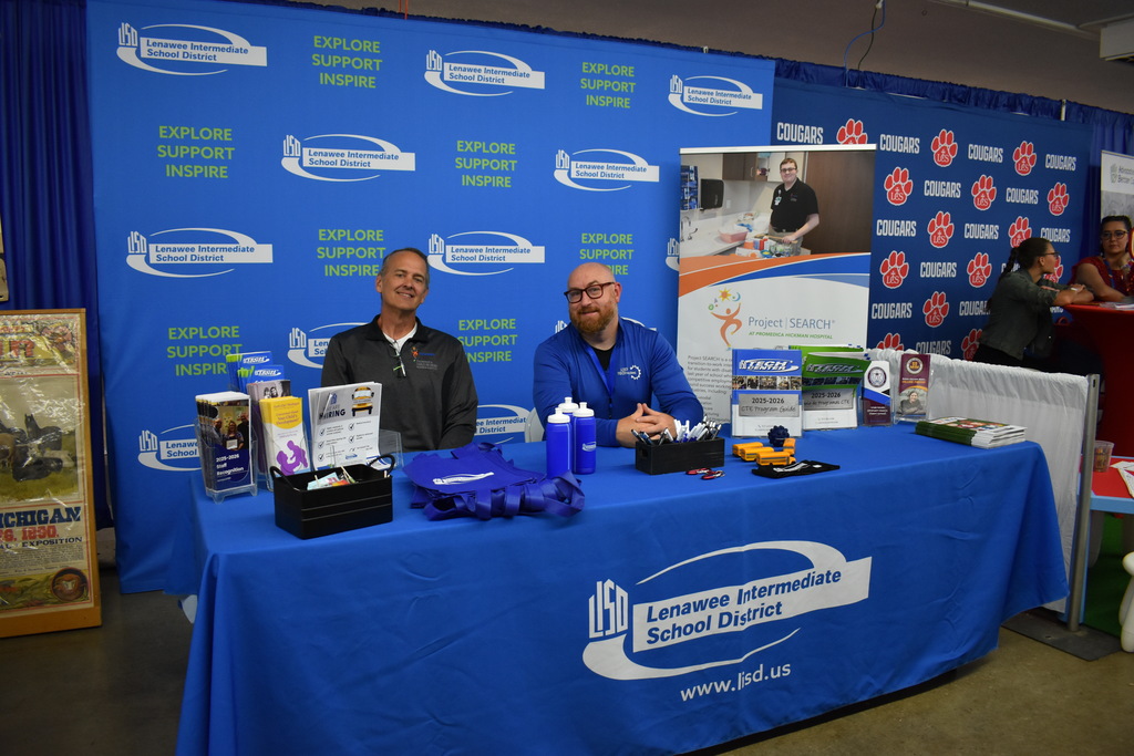 LISD staff members Kurt and Ben sitting at the LISD booth at the fair
