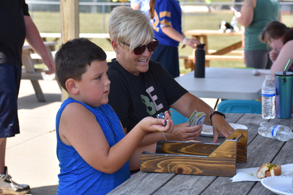 A student and a teacher sitting at a picnic table getting a game out