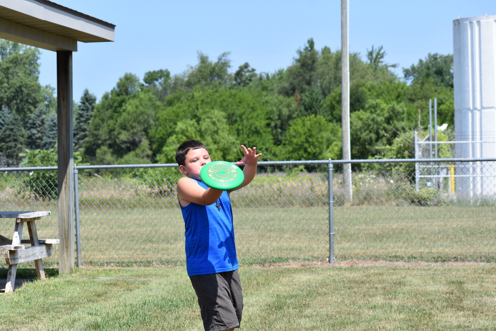 a student catching a frisbee outside on a playground
