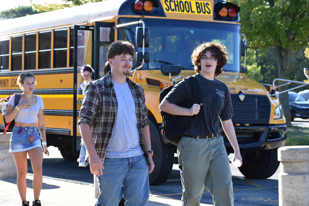 Students exiting the bus and walking toward the building