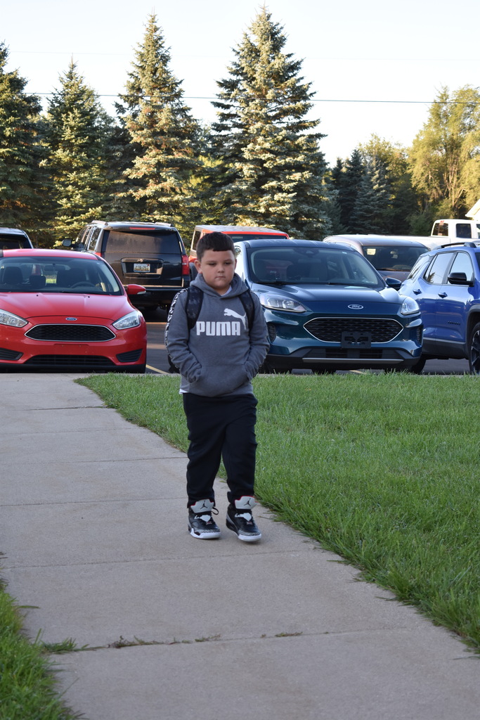 A young student walking toward the building