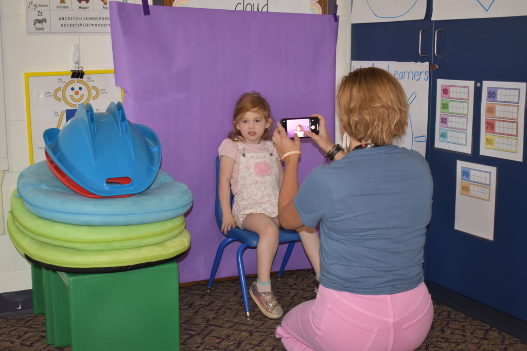 A teacher taking a new student's photo