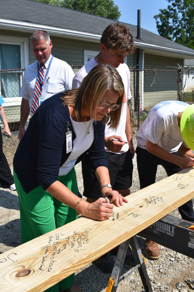 Assistant Superintendent signing the board along with a couple students who are also signing