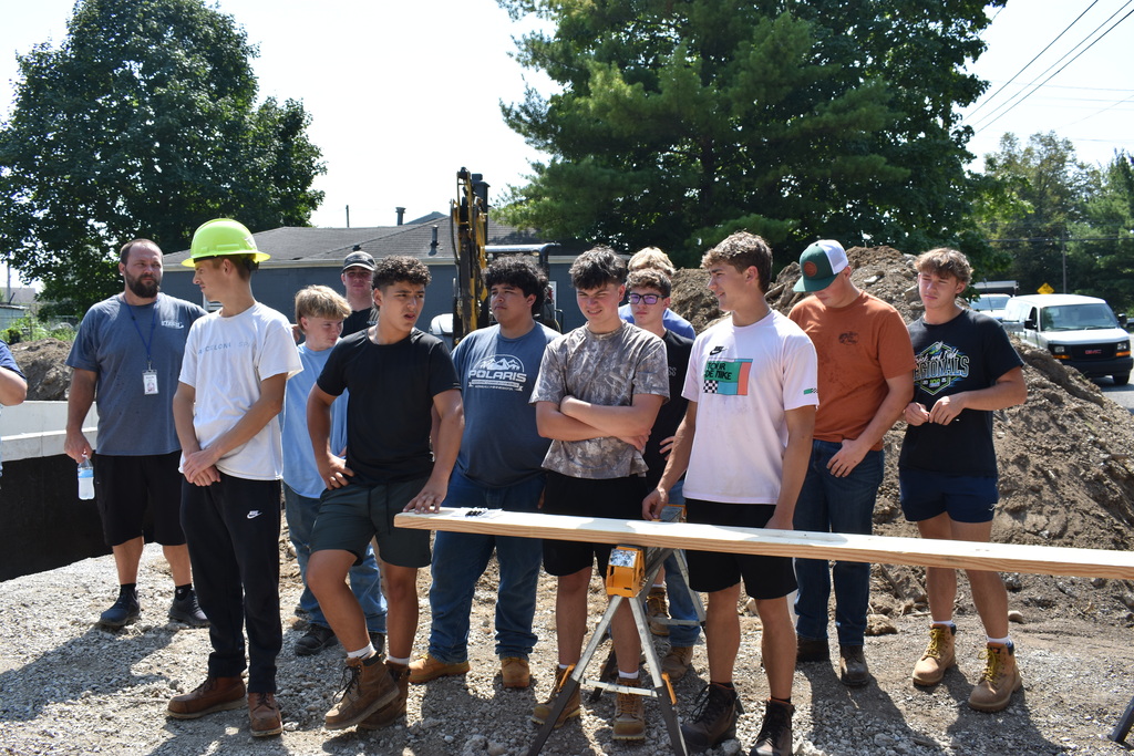 The instructor and students standing at the site in a group