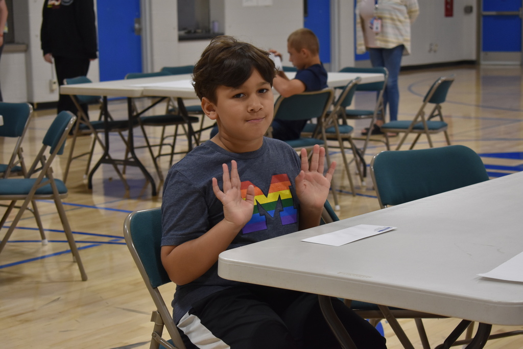 A student looking at the camera from their seat