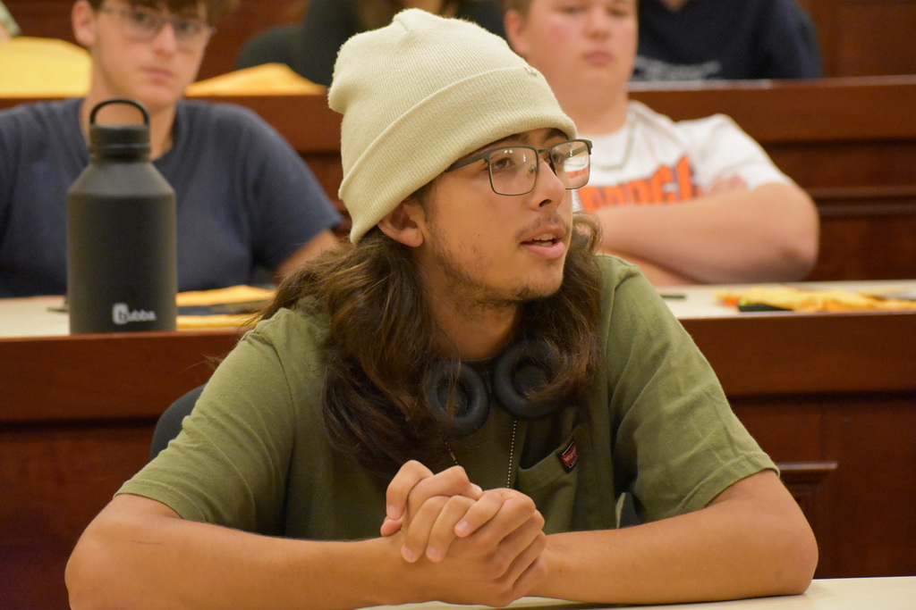 A student who just finished answering a question while seated in an auditorium 