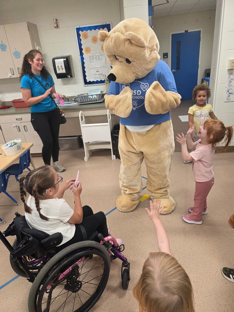 Children greet and welcome Barry the bear. 