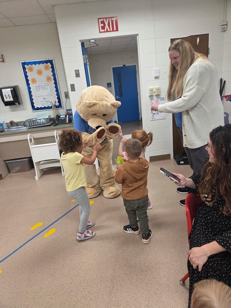 Children with Barry the bear giving high fives and fist bumps.