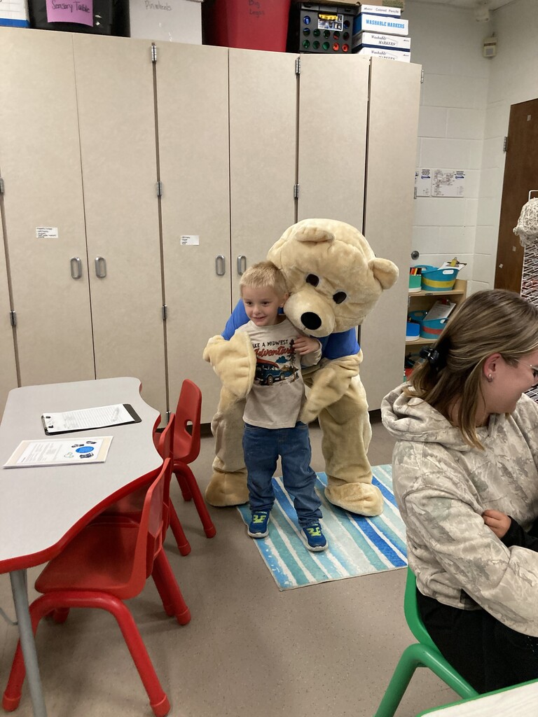 Child getting hugged by Barry the Bear.
