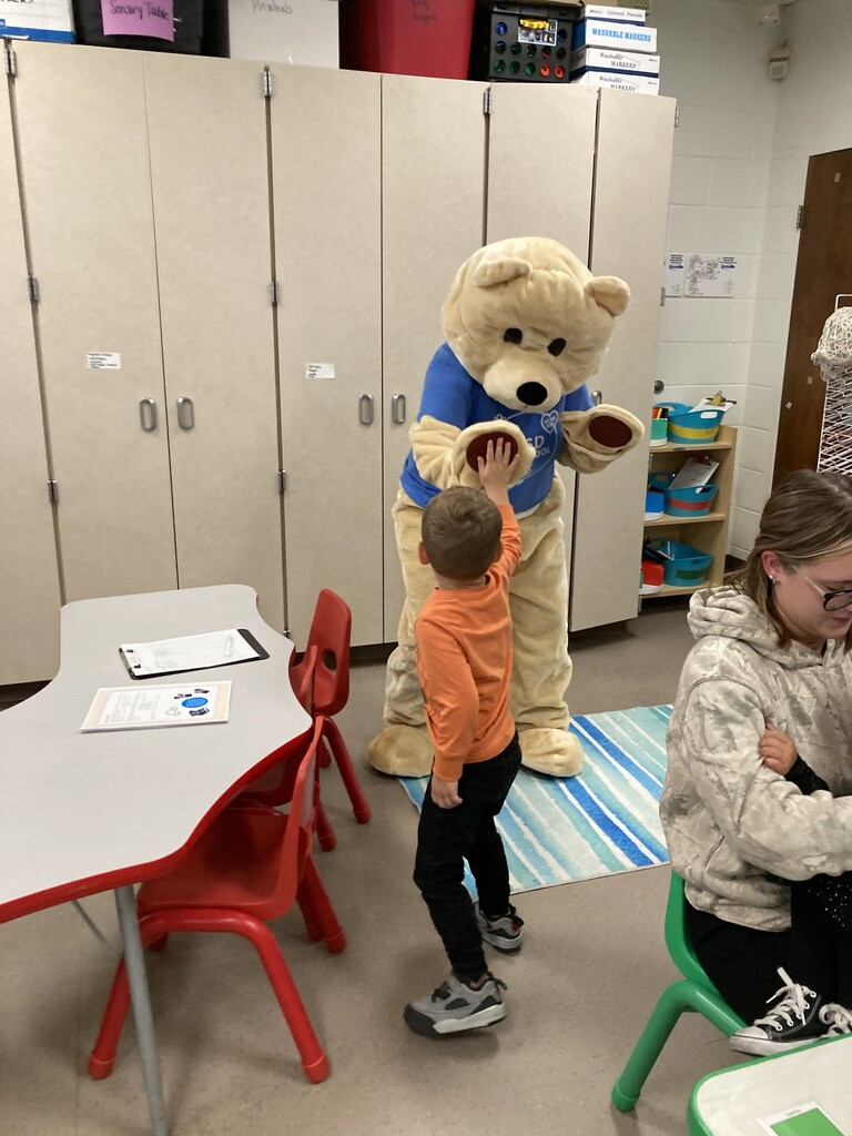 Student giving high five to Barry the Bear.