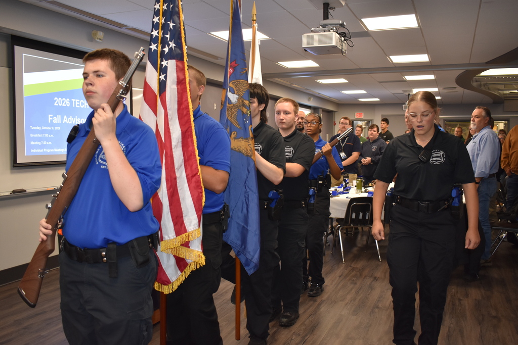 The Law Enforcement Program Color Guard doing a presentation of the flags in an auditorium setting.