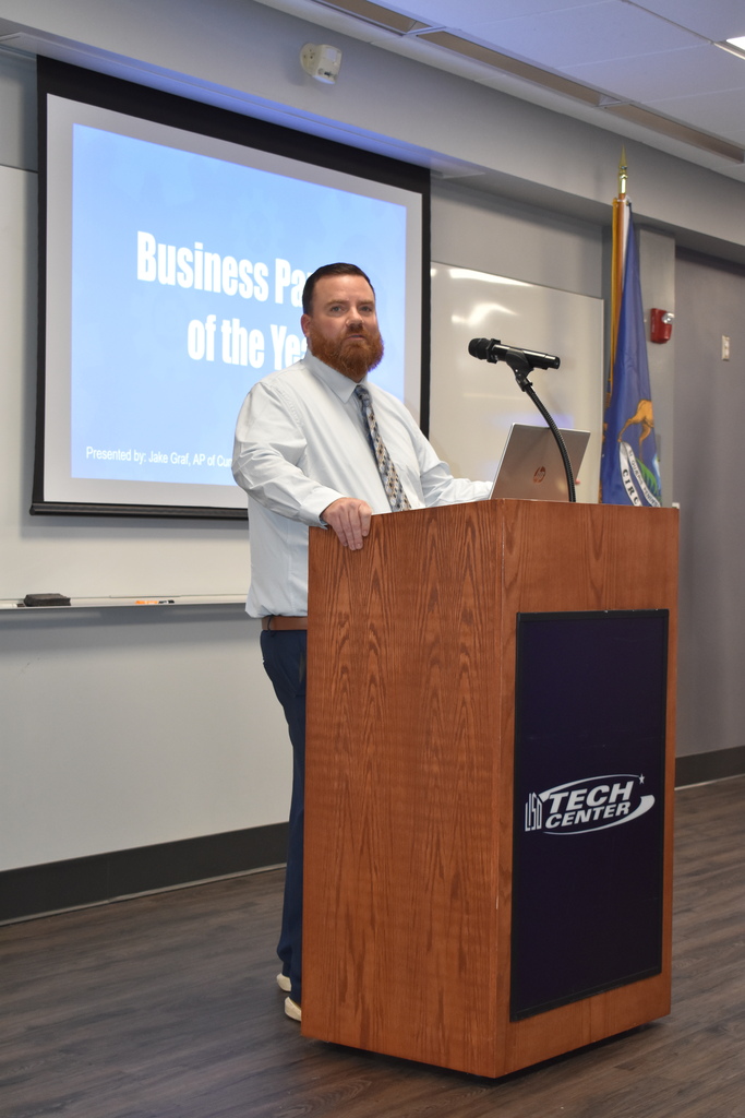Assistant Principal Jake Graf at the podium with the TECH Center logo on it in a classroom setting.