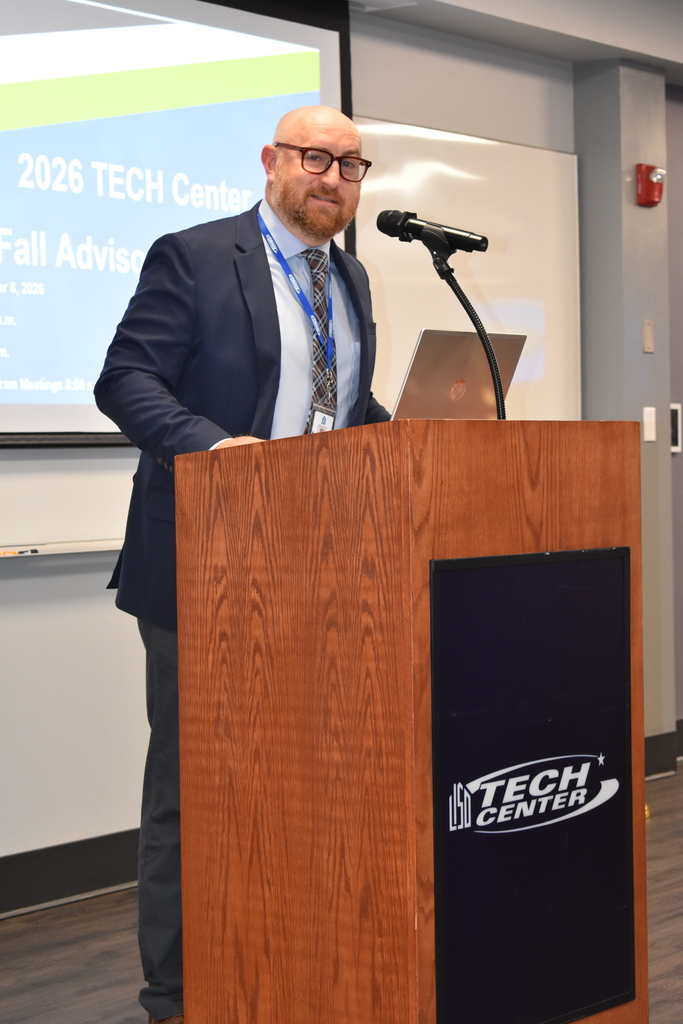 Principal Ben Murray at the podium with the TECH Center logo on it in a classroom setting.