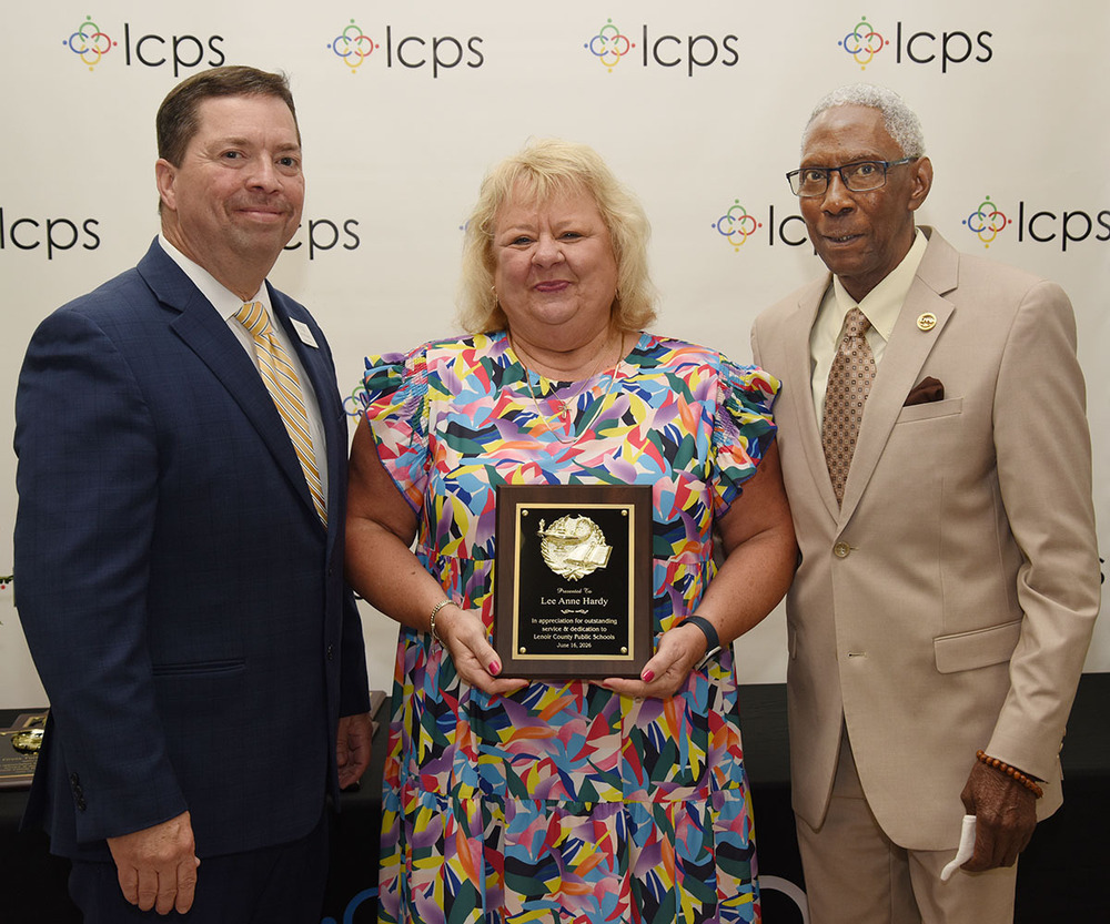 A retiree stands with school officials at the annual retirement banquet