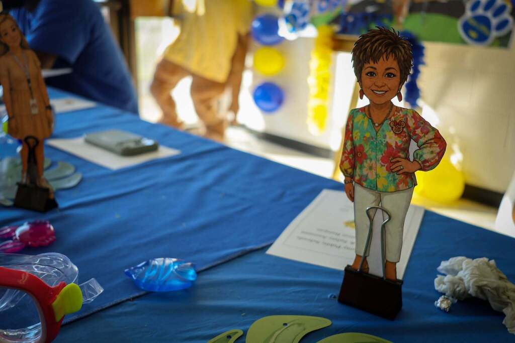 A cutout of a bus driver stands on a table with blue decorations surrounding it