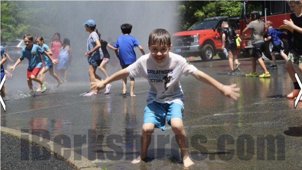 Pupils at Morris Elementary get doused with water from the Fire Department's hose at Friday's field day.