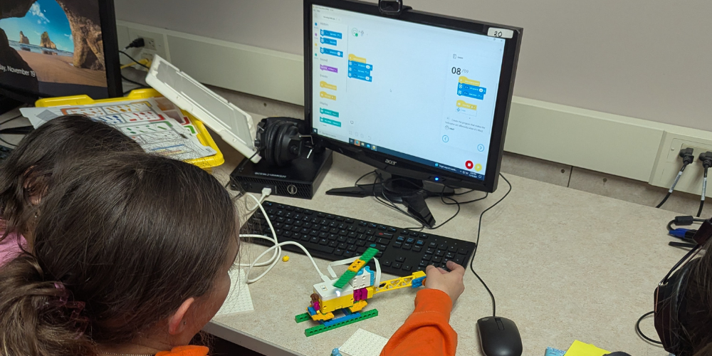 Students work with lego robotics and computers
