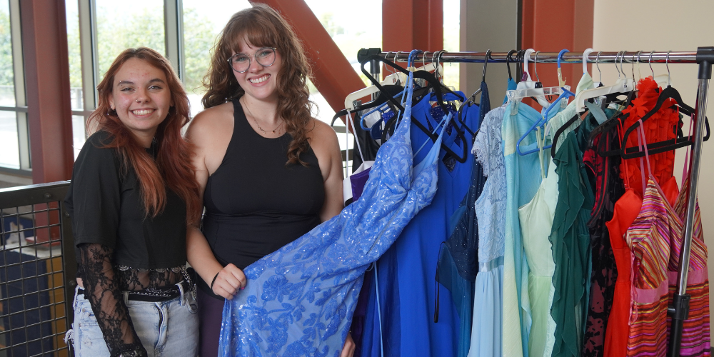 Abigail Kane and Lucy Caving pose for a picture with homecoming dresses