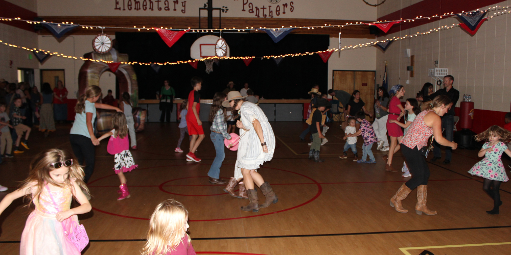 students and teachers dancing in the palmer lake elementary gym
