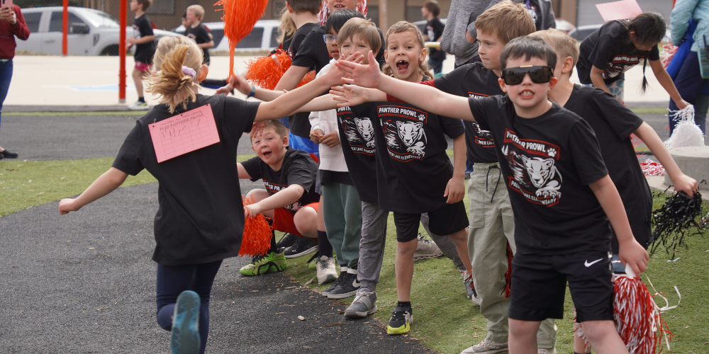 Palmer Lake Elementary students cheer on and give high fives to other students as they run during the Panther Prowl