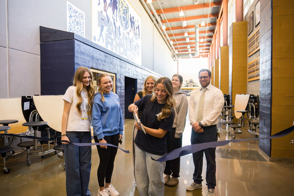Lauren Russo cuts the ribbon at her mural opening celebration.