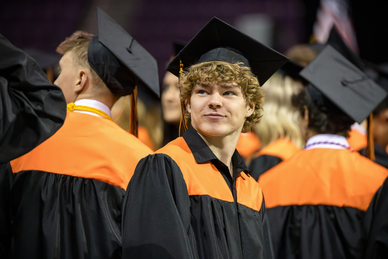 Boy graduate in a crowd.