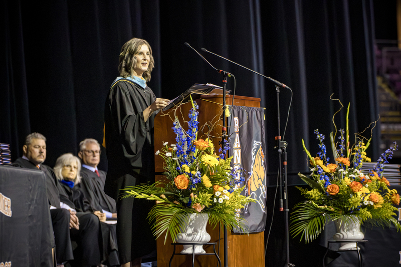 Female superintendent speaks at the podium at graduation.