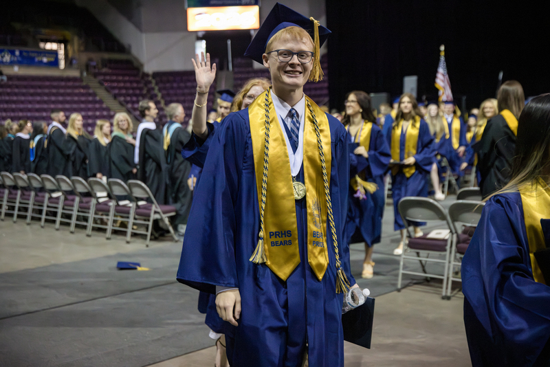 Valedictorian smiling as he walks out of graduation