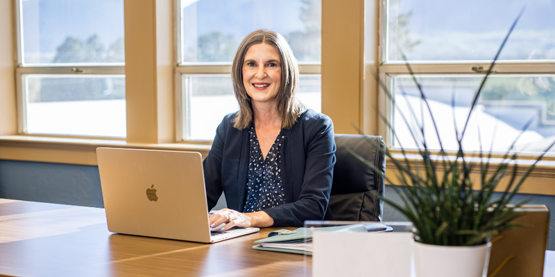 Amber Whetstine sitting at her office desk smiling