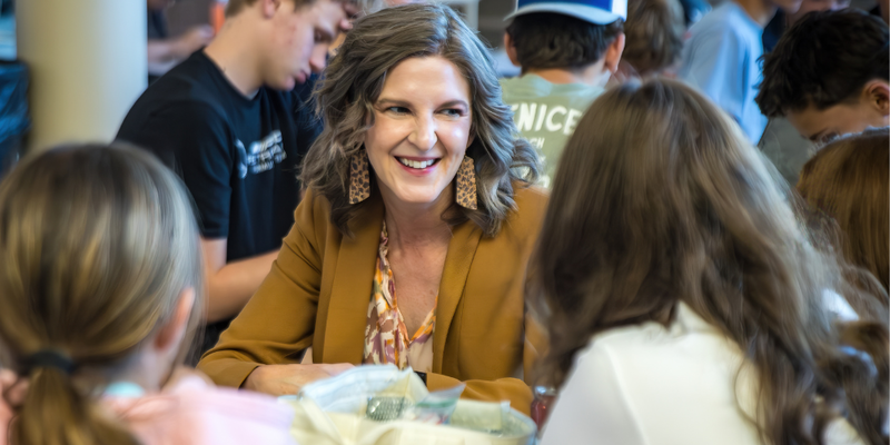 Amber whetstine smiling as she sits and talks with students