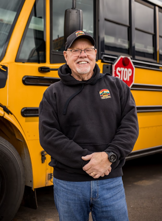 john res standing in front of a bus smiling
