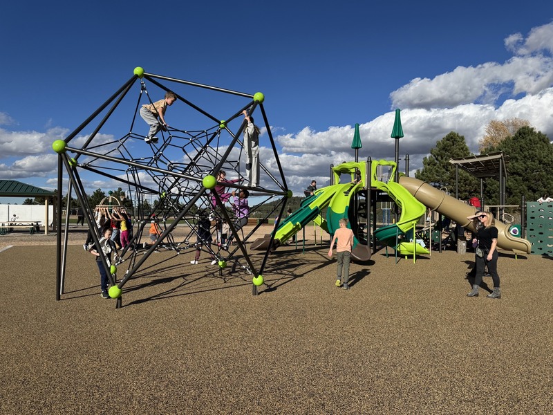 New playground equipment with students playing on it.