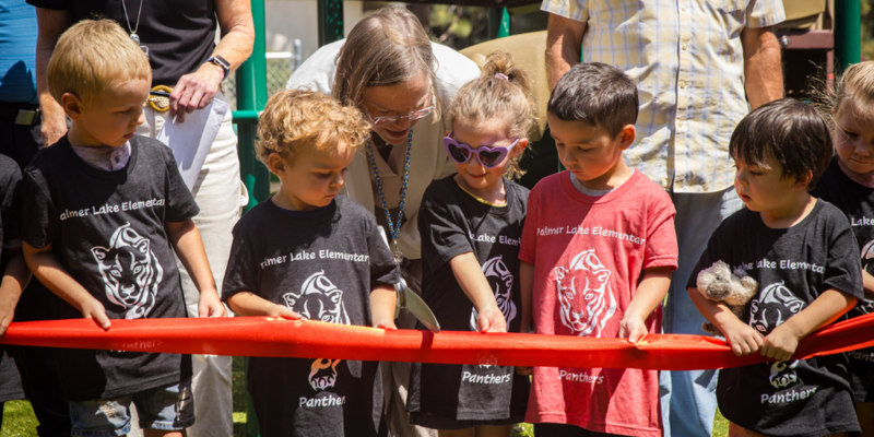 Students and staff help cut the ribbon to open the new Palmer Lake Elementary preschool playground