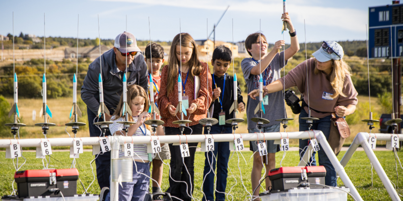 Students and volunteers prepare their rockets for launch