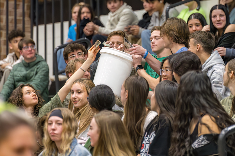 Students at the Wish Assembly passing a bucket around to donate money to Make-A-Wish Colorado