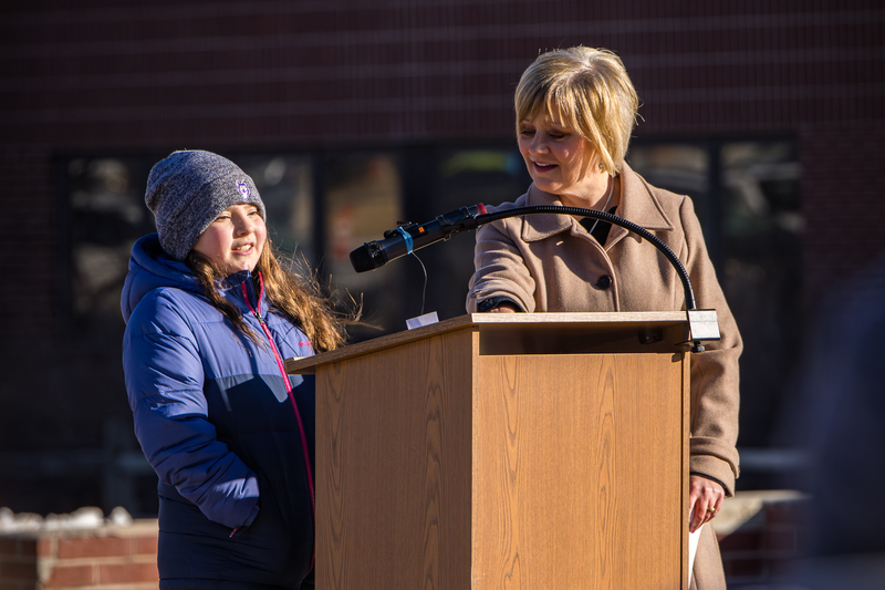 Student Ellie Torres speaks at the ceremony, accompanied by D38 Comms Director Amy Matisek 