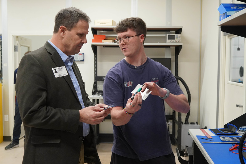A student shows  Rep. Crank something he built in the CIC.