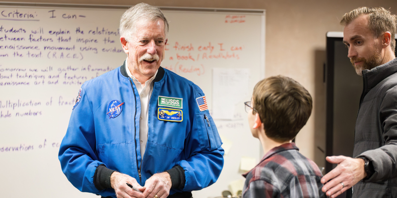 Astronaut Jim Reilly speaks to a student during STEAM Night
