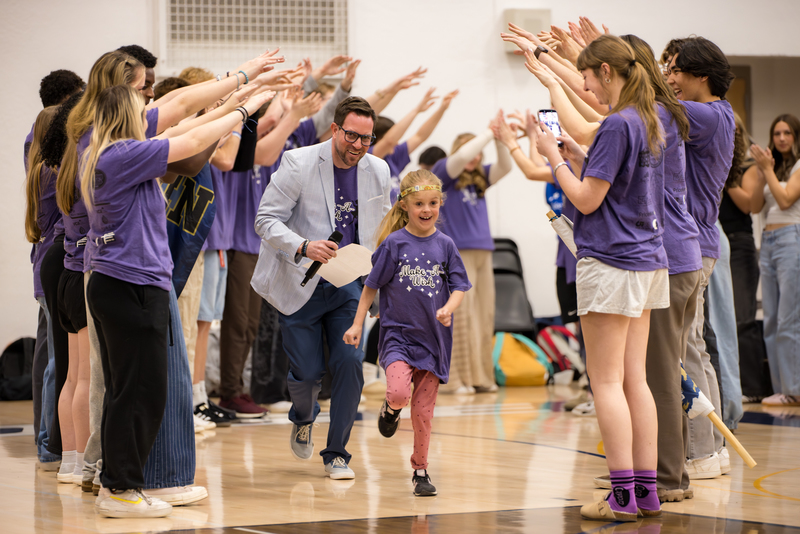 Brooks and Principal Frank run to center court through a human tunnel