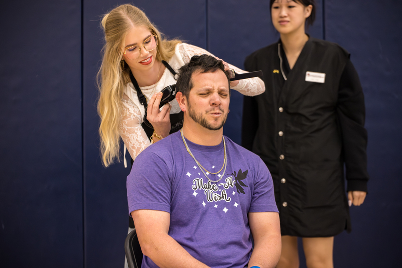 Teacher Daniel Russel getting his head shaved