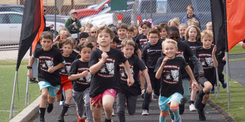 Palmer Lake Elementary students cheer on and give high fives to other students as they run during the Panther Prowl