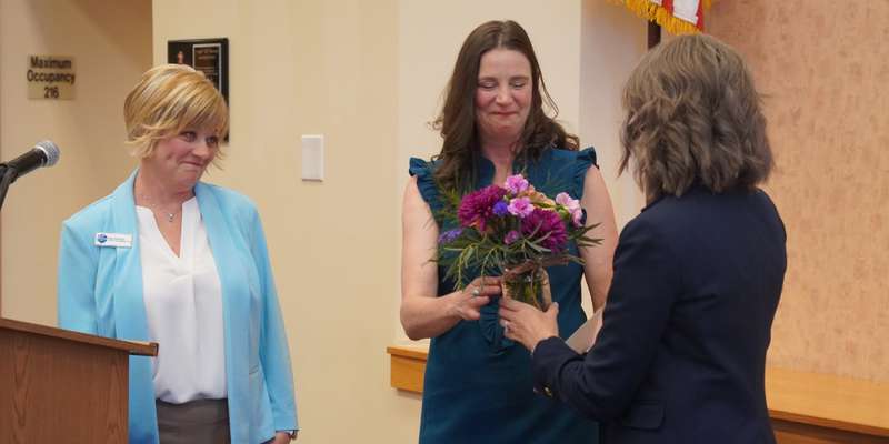 Art teacher Amanda Staman receiving a flower bouquet from Superintendent Amber Whetstine