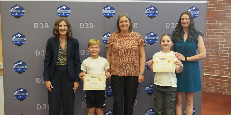 Winning art works hung on the wall and displayed on a table